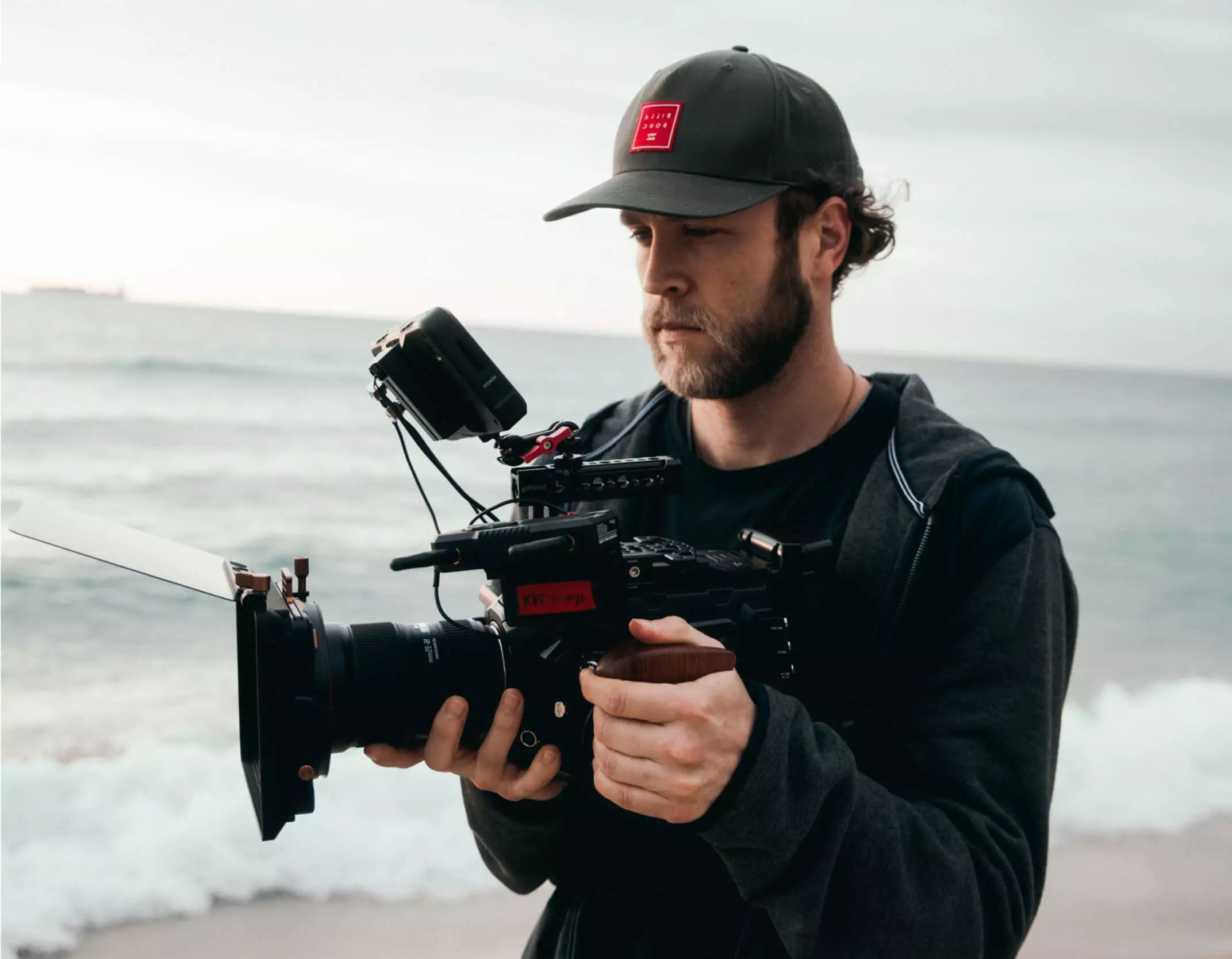 Productor audiovisual con su camara de filmación en la playa Productor audiovisual con su camara de filmación en la playa